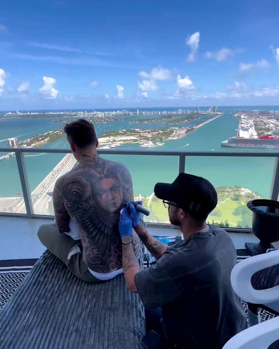Xavi tattooing on a rooftop overlooking Miami